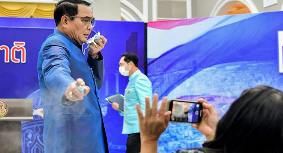 El primer ministro tailandés en momentos en que rociaba alcohol en plena rueda de prensa. Foto: Twitter @educativa_rd
