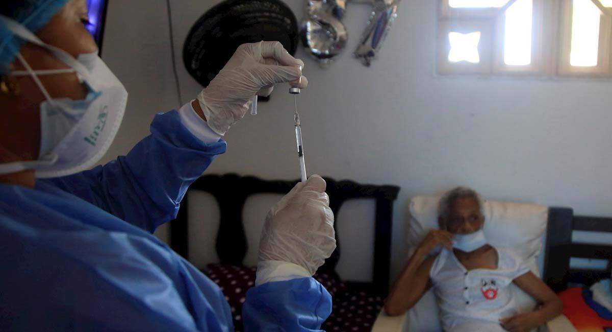 Una enfermera prepara una dosis de la vacuna Sinovac para inmunizar a una señora mayor de 80 años. Foto: EFE