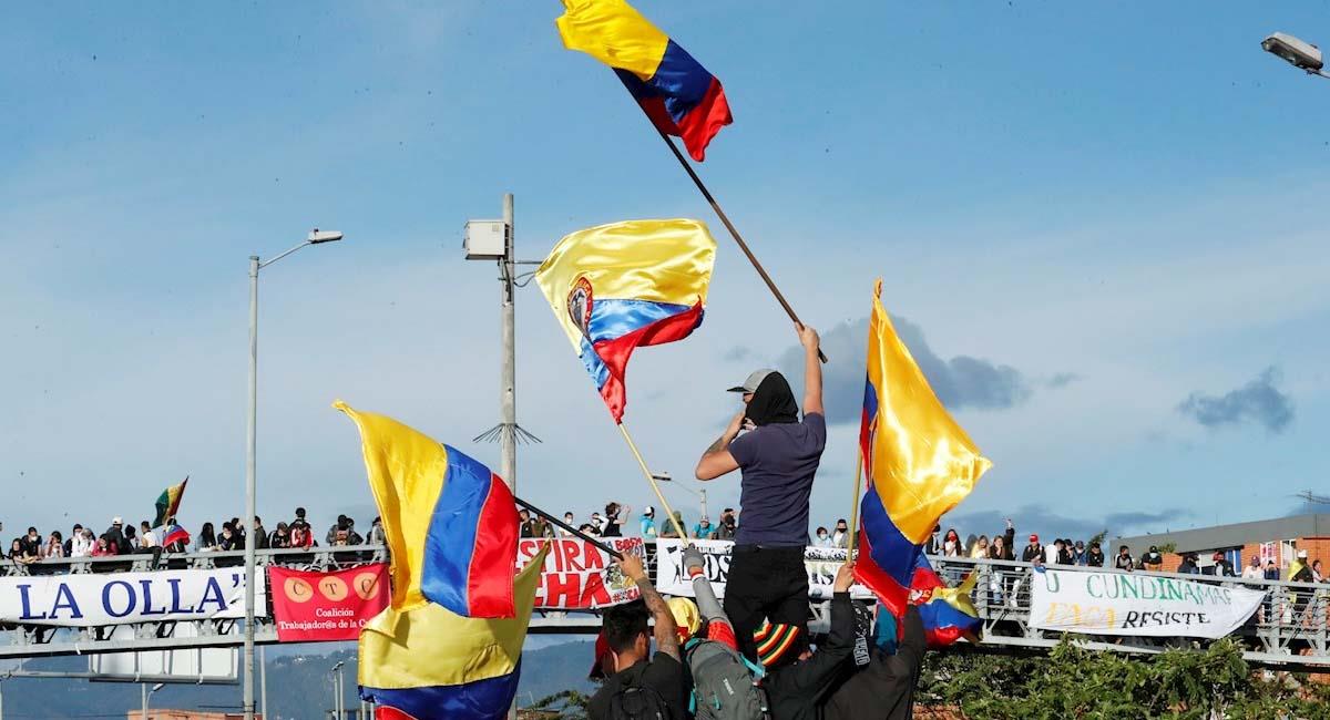 Manifestantes ondean banderas de Colombia durante una jornada del paro nacional en Bogotá. Foto: EFE