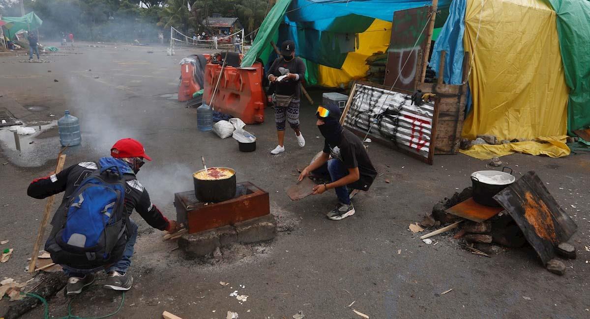 Manifestantes cocinan en un punto donde se mantiene un bloqueo en Cali. Foto: EFE