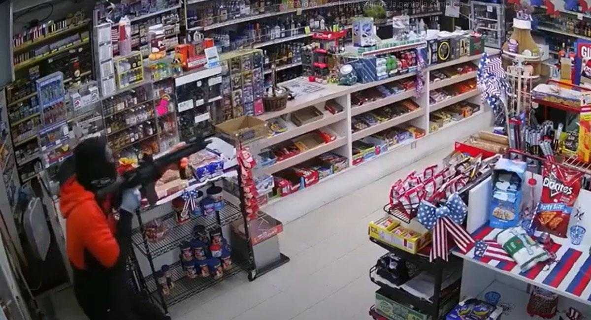 Momento en el que un ladrón apunta al dueño de un  supermercado con un rifle. Foto: Youtube
