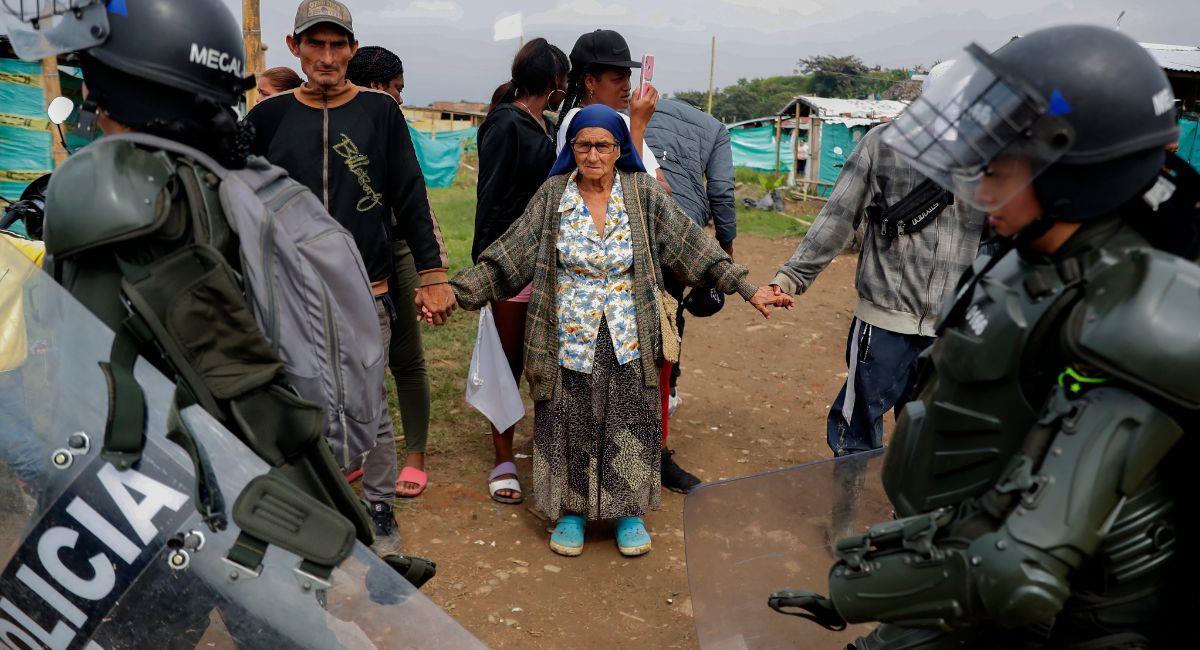 Habitantes se toman hoy de las manos para evitar el desalojo de un predio invadido por 1.500 familias. Foto: EFE EFE/ Ernesto Guzmán