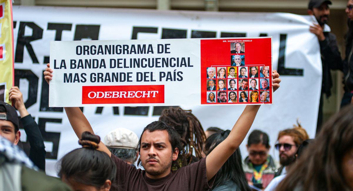 Manifestante opositor sostiene fotos de políticos cercanos a Álvaro Uribe que pueden estar involucrados en el escándalo de ODEBRECHT. Foto: Shutterstock Sebastian Barros