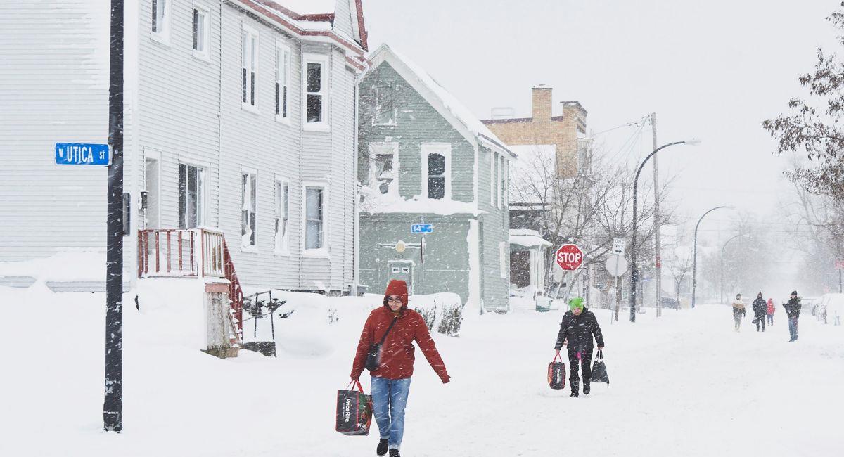 Las personas llevan comestibles a lo largo de una avenida Massachusetts cubierta de nieve en West Buffalo como los efectos de una tormenta de invierno masiva que ha afectado a gran parte de los Estado. Foto: EFE EFE/EPA/JOSH THERMIDOR
