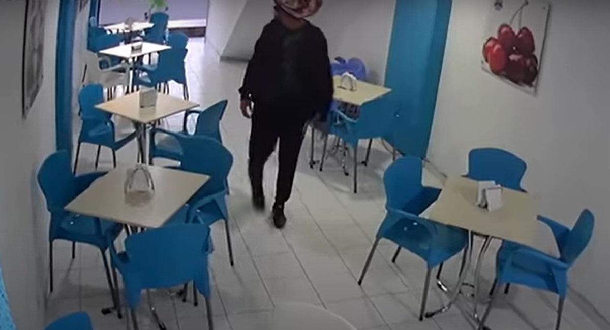 Momento en el que un ladrón ingresa a una heladería de Bello para robar a tres mujeres. Foto: Youtube