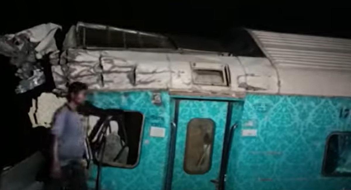 Un hombre pasa frente a un vagón destruido de un tren que se vio envuelto en una fatal colisión en India. Foto: Youtube